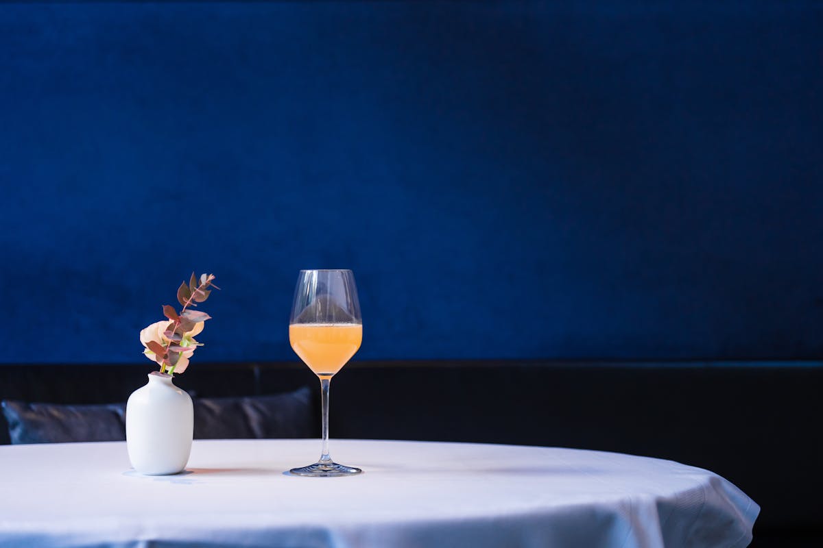 a glass with a blue vase on a table